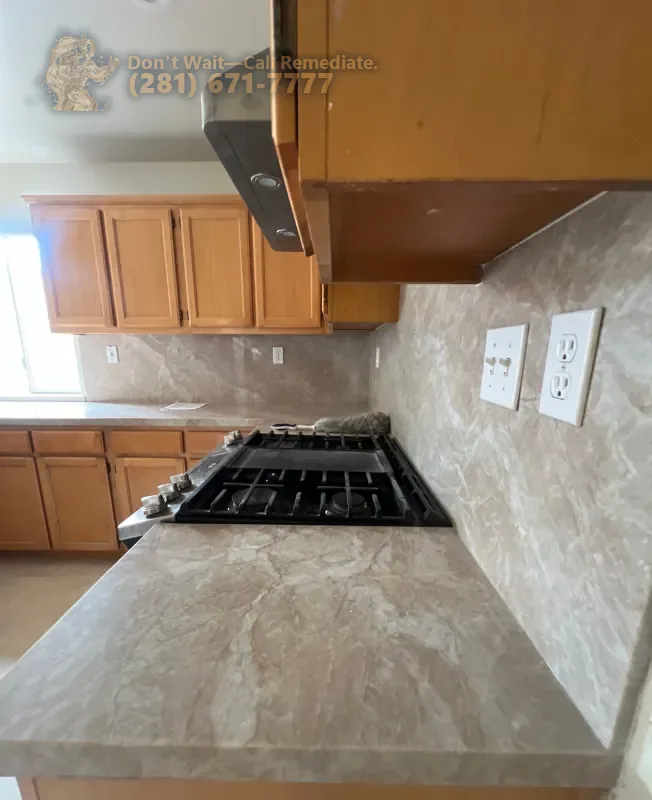 Stone countertop and full-height backsplash beside the cooktop