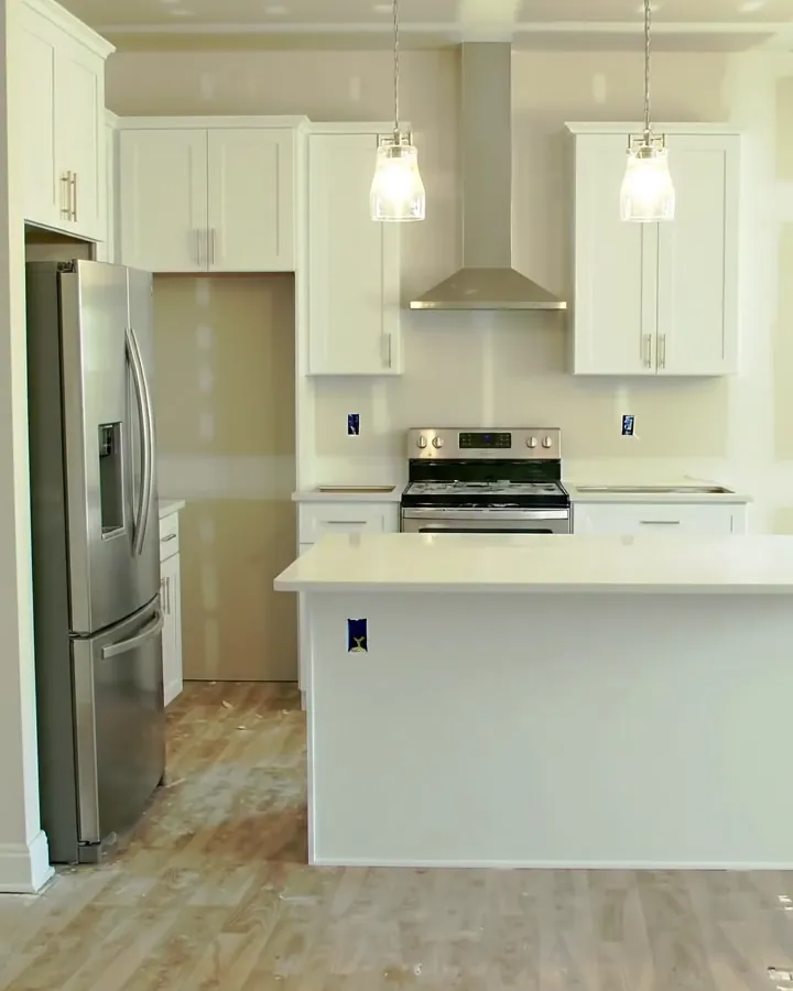 Illustration: a finished white kitchen with stone counters, a subway tile backsplash and pendant lights